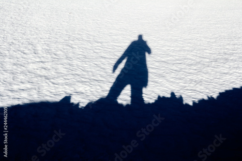 silhouette of a man on snow in sunny winter day