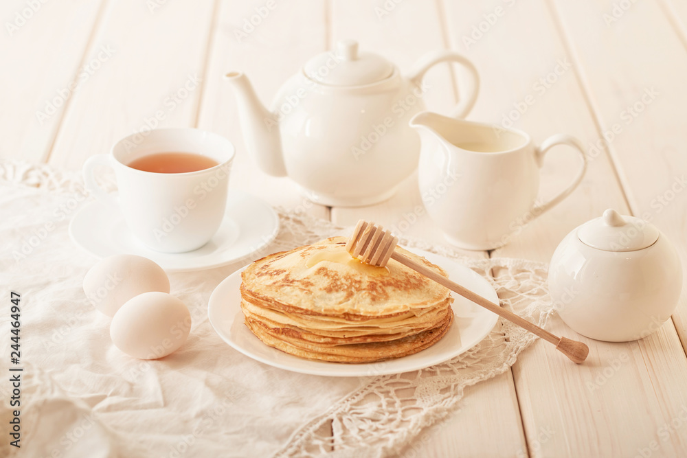 Healthy summer breakfast, homemade classic american pancakes with honey,cozy morning, copy space. Pancakes, teapot, honey on white wooden table. Pancake week. russian traditional holiday Maslenitsa Healthy summer breakfast, homemade classic american pancakes with honey,cozy morning, copy space. Pancakes, teapot, honey on white wooden table. Pancake week. russian traditional holiday Maslenitsa