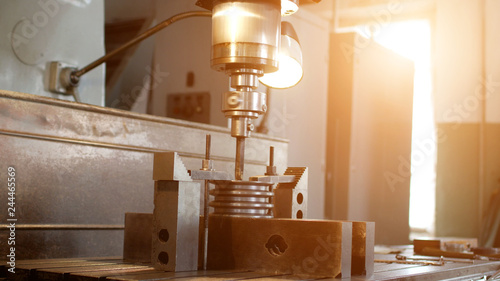 Drilling a hole with a drilling machine in a metal workpiece pulley, close-up, industry, manufacturing gin