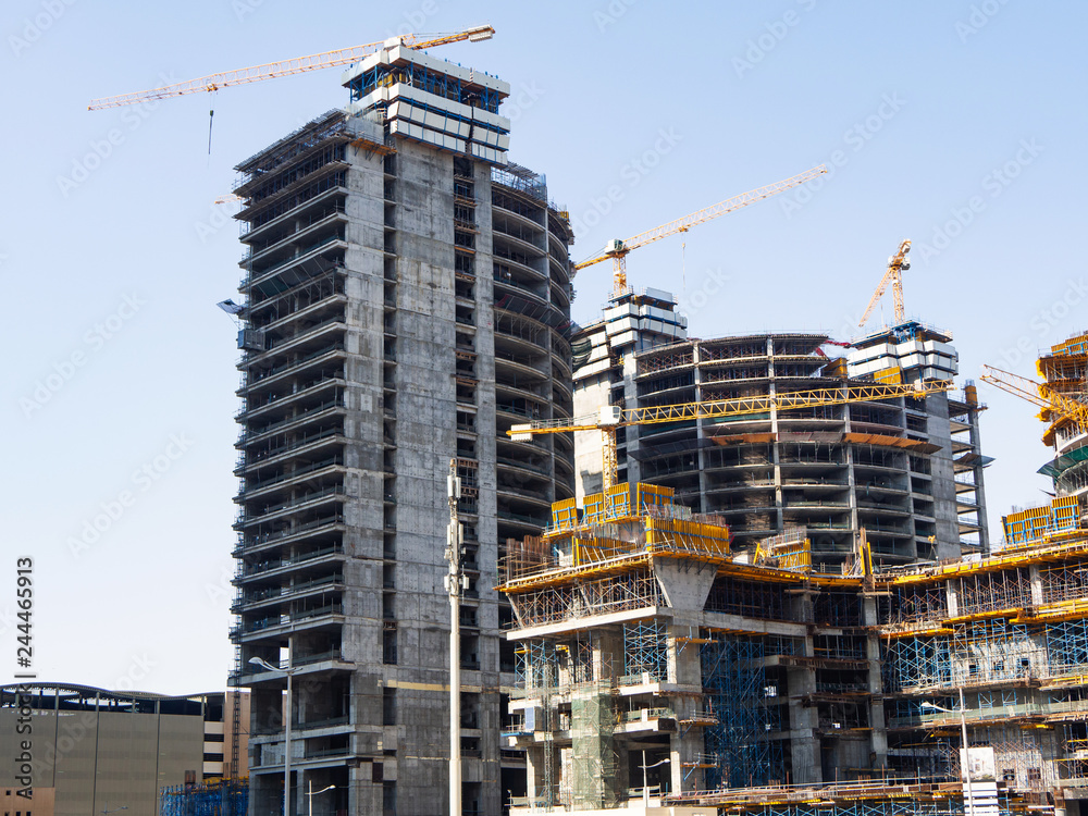 High-rise buildings under construction with cranes and scaffolding