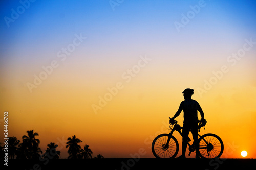 Silhouette of cyclist with mountain bike on beautiful sunset time at the beach