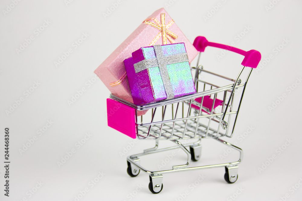 shopping cart with gift boxes on light background