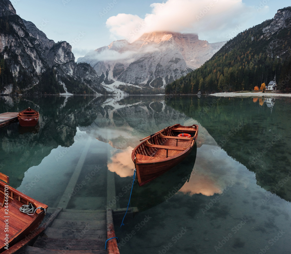 Awesome plase to rest. Wooden boats on the crystal lake with majestic mountain behind. Reflection in the water