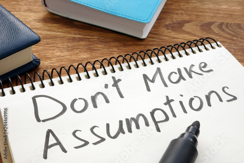 Don't Make Assumptions. Notepad with marker on a table. photo