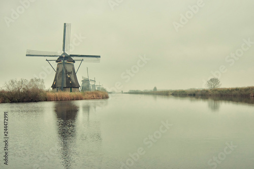 The Famous Netherlands wooden Windmills, UNESCO World Heritage Site, Kinderdijk Windmill village in the soft sunset light of winter with vintage style.