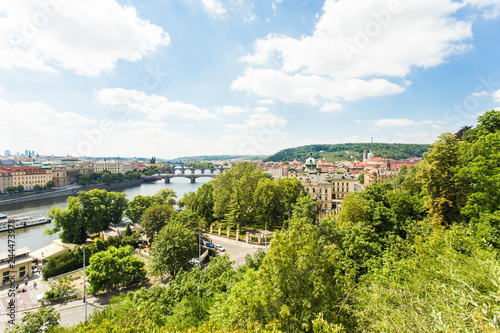 Scenic view of bridges on the Vltava river and of the historical center of Prague: buildings and landmarks of old town with red rooftops and multi-coloured walls.