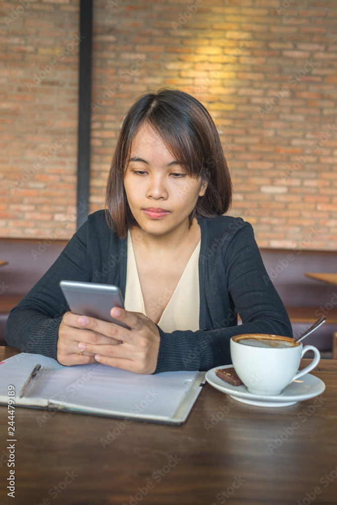 Vertical photo of woman using smartphone in the coffee shop Vertical photo of woman using smartphone in the coffee shop