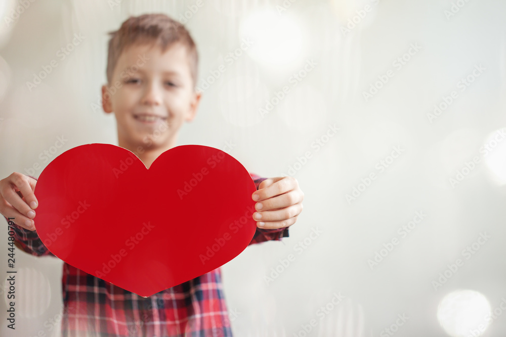 Cute sweet boy with red paper heart on background. Valentines day, Mothers Day and Love concept Cute sweet boy with red paper heart on background. Valentines day, Mothers Day and Love concept