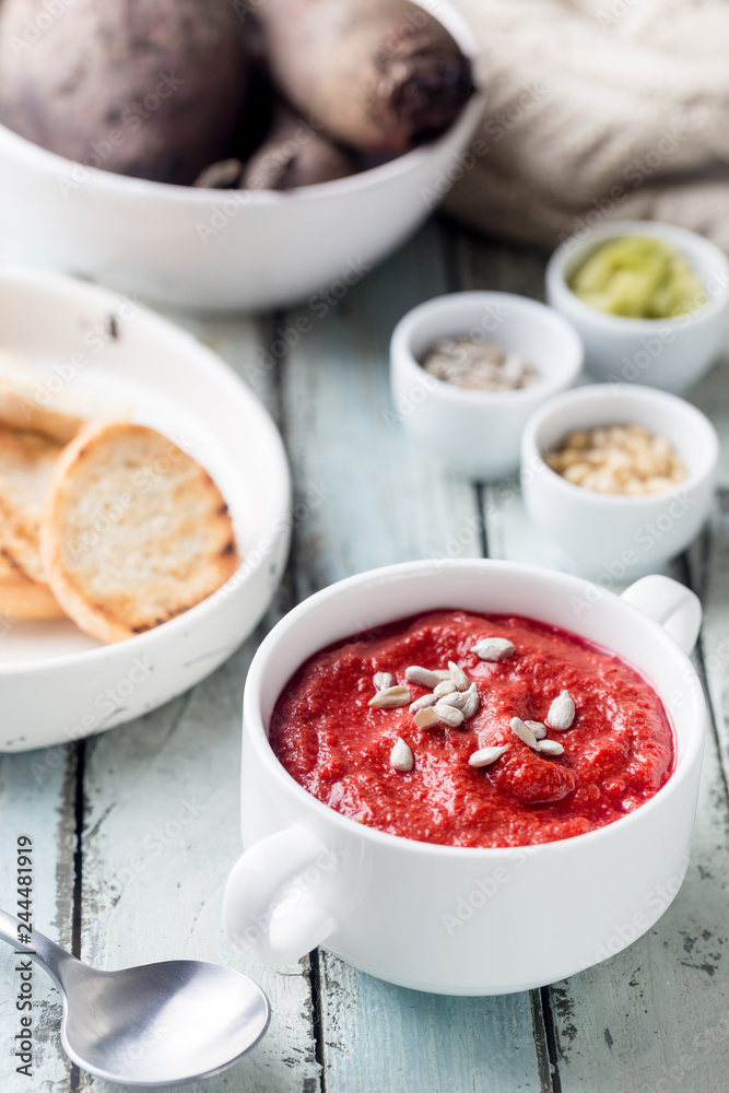 Red Beetroot mashed soup with cream and sunflower seeds in a white bowl. Red Beetroot mashed soup with cream and sunflower seeds in a white bowl.