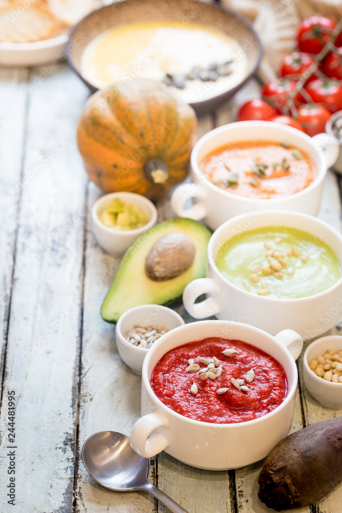Variety of different colorful vegetable cream soups in a bowls. Concept of healthy eating or vegetarian food. Variety of different colorful vegetable cream soups in a bowls. Concept of healthy eating or vegetarian food.
