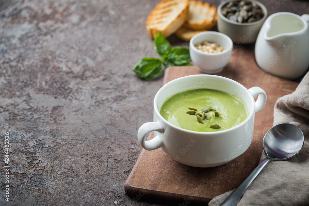 bowl of broccoli and green peas cream soup in a white bowl with avocado bowl of broccoli and green peas cream soup in a white bowl with avocado