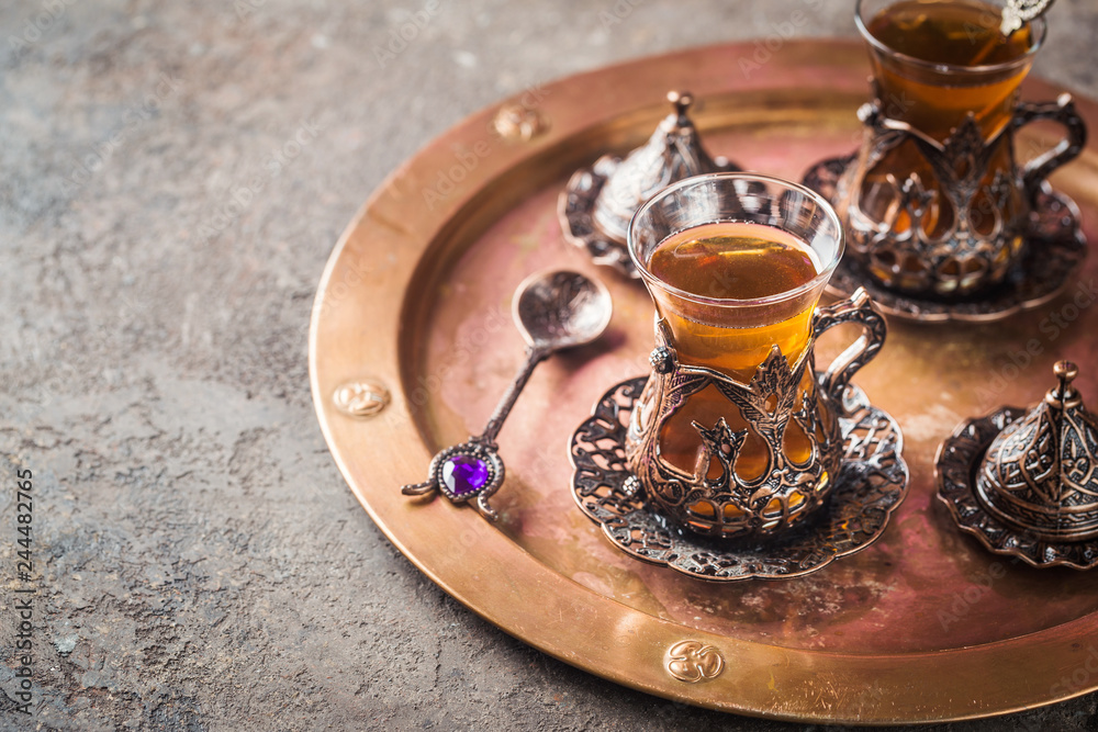 Turkish tea in traditional glass on tray closeup Turkish tea in traditional glass on tray closeup