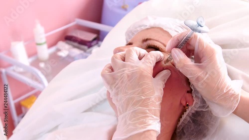 Filler injection for female face. Hand in gloves with syringe injects drug photo