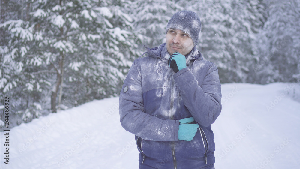 Frozen man in the winter forest is thinking