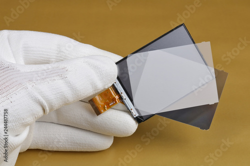 A technician controls the quality of a modern lcd screen for digital camera photo
