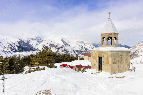 Monastery Saint Ilya at mountain top. View of Mount Kazbek and Holy Trinity Cathedral (Trinity Church). Stepantsminda, Kazbegi, Georgia