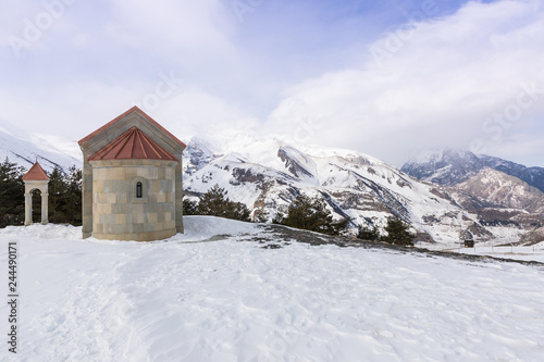 Monastery Saint Ilya at mountain top. View of Mount Kazbek and Holy Trinity Cathedral (Trinity Church). Stepantsminda, Kazbegi, Georgia