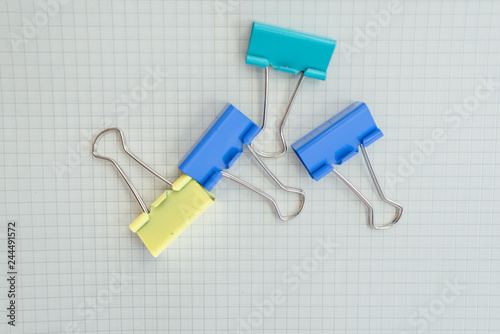 colored paper clips on a pink background. Office stationary