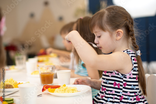 children eating healthy food in daycare centre or kindergarten