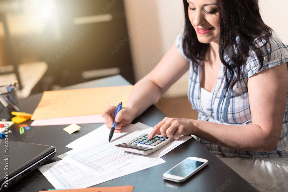 Female accountant using calculator Female accountant using calculator