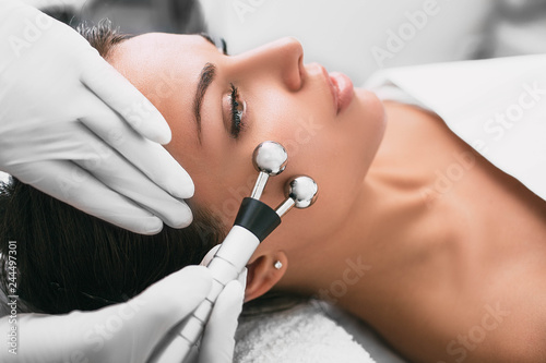 Beautiful woman receiving facial microcurrent procedure for lifting skin. Facial rejuvenation and facelift with microcurrent therapy