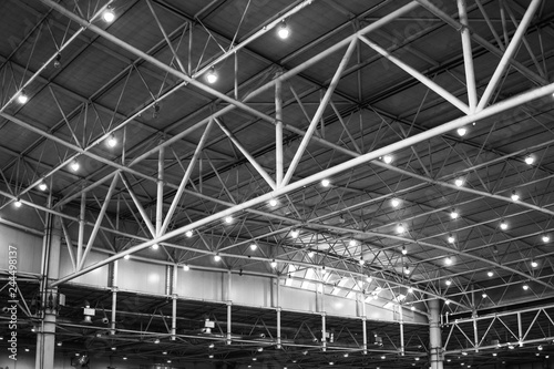Interior of warehouse. large metal structures  ceiling. roof. concept production and installation of equipment for rooms  lighting  ventilation and windows for hangars  black and white