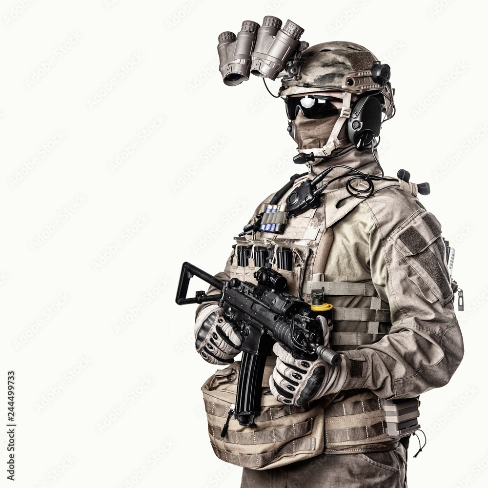 Army elite soldier with hidden behind mask and glasses face, in full tactical ammunition, equipped night vision device, radio headset, armed short barrel service rifle studio shoot on white background