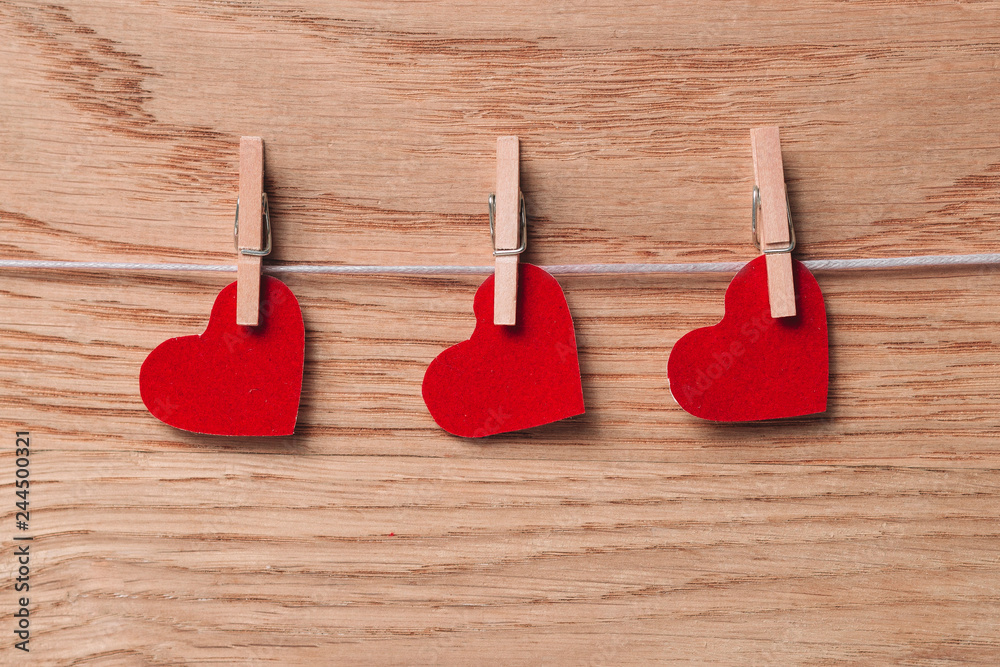red hearts on clothespins on wooden background red hearts on clothespins on wooden background