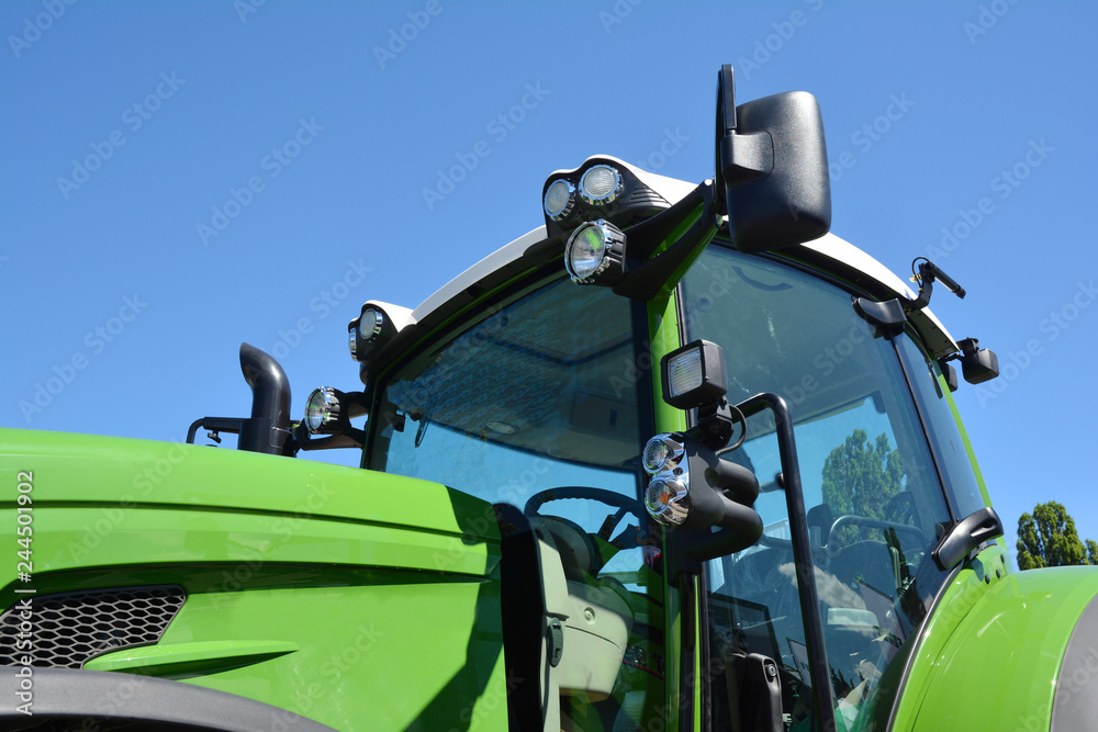 Obraz premium Modern tractor cabin. New green tractor with headlights.