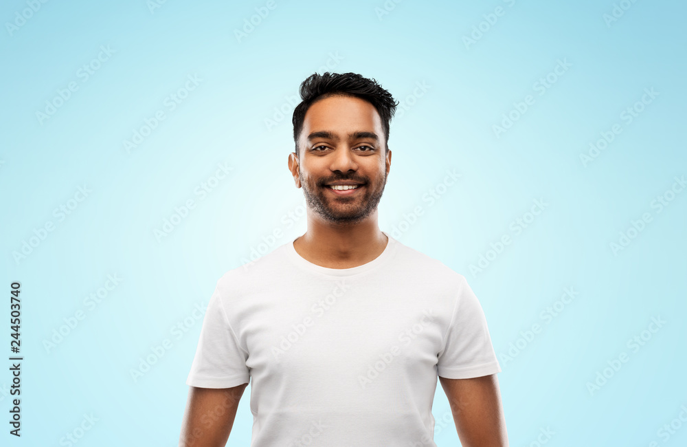 people concept - smiling young indian man over blue background people concept - smiling young indian man over blue background