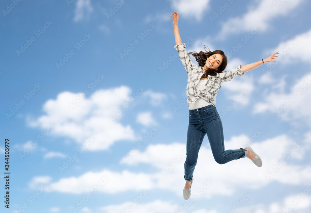 motion, freedom and people concept - happy young woman or teenage girl jumping over blue sky and clouds background motion, freedom and people concept - happy young woman or teenage girl jumping over blue sky and clouds background