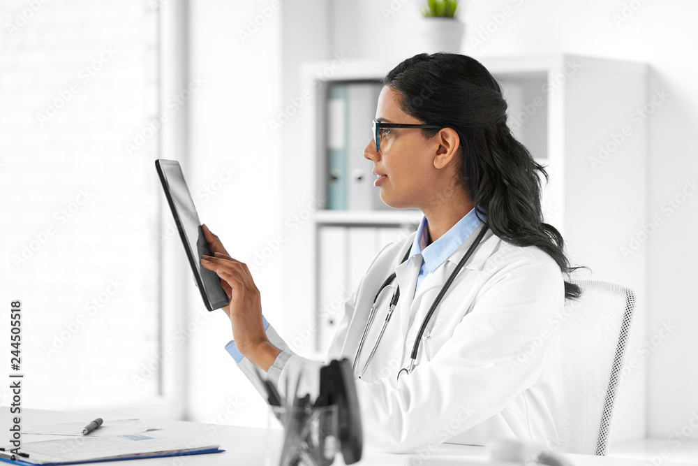 healthcare, technology, people and medicine concept - indian female doctor in glasses with tablet pc computer in medical office at hospital healthcare, technology, people and medicine concept - indian female doctor in glasses with tablet pc computer in medical office at hospital
