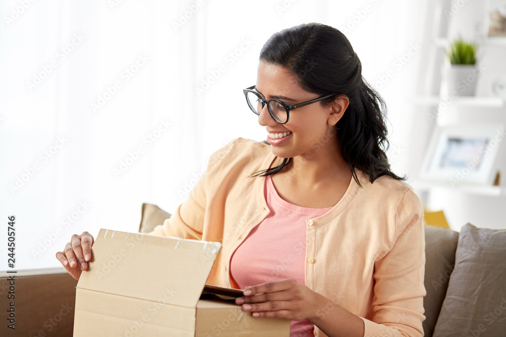 people, mail delivery and shipping concept - happy indian woman opening parcel box at home people, mail delivery and shipping concept - happy indian woman opening parcel box at home