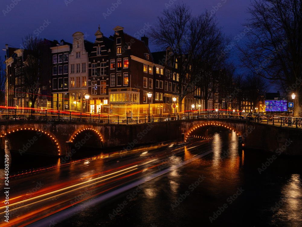 beautiful canals of amsterdam by night with light trails