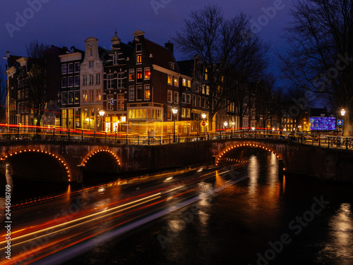 beautiful canals of amsterdam by night with light trails