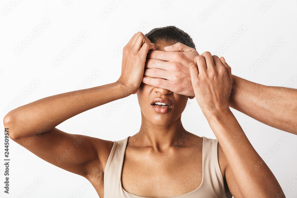 Scared young african woman sitting while man's hand Scared young african woman sitting while man's hand