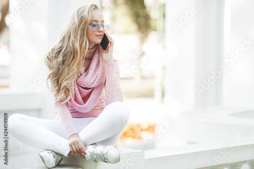 Attractive young woman making selfie outdoor. Casual girl talking on the cell phone in the park. Attractive young lady chatting with her friends by mobile.