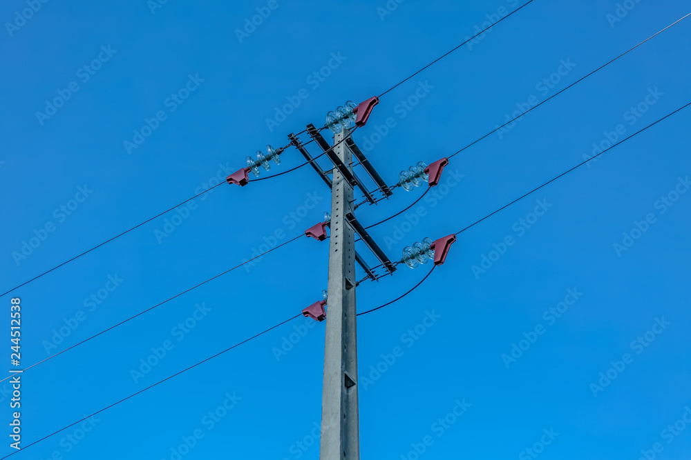 View of electricity pole and power lines with blue sky as background View of electricity pole and power lines with blue sky as background