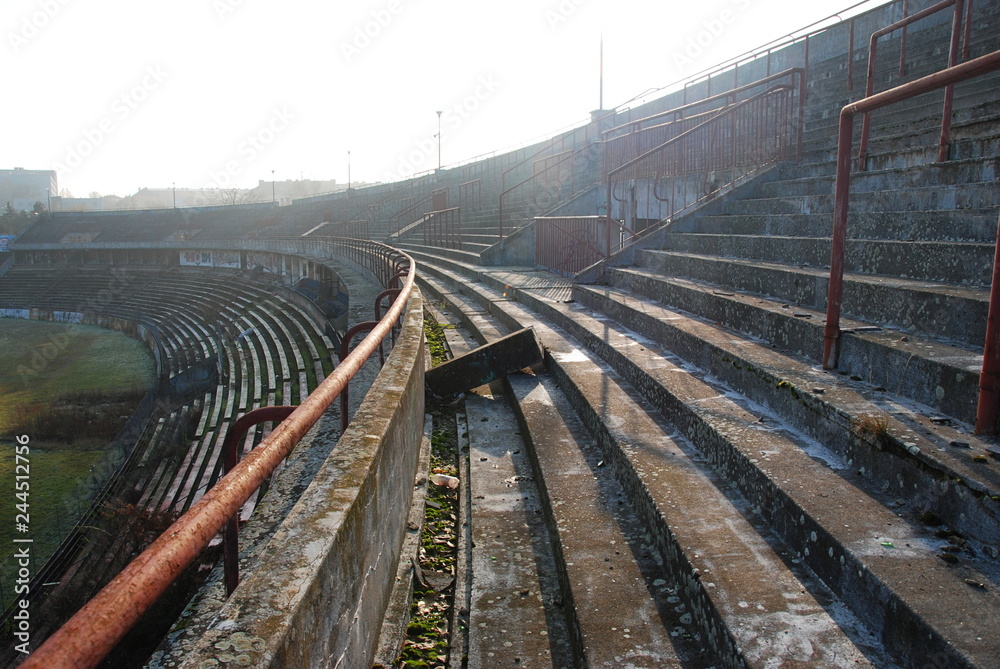 Empty tribunes of abandoned and decaying football stadium, urbex