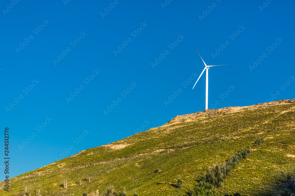 View of a wind turbine on top of mountains