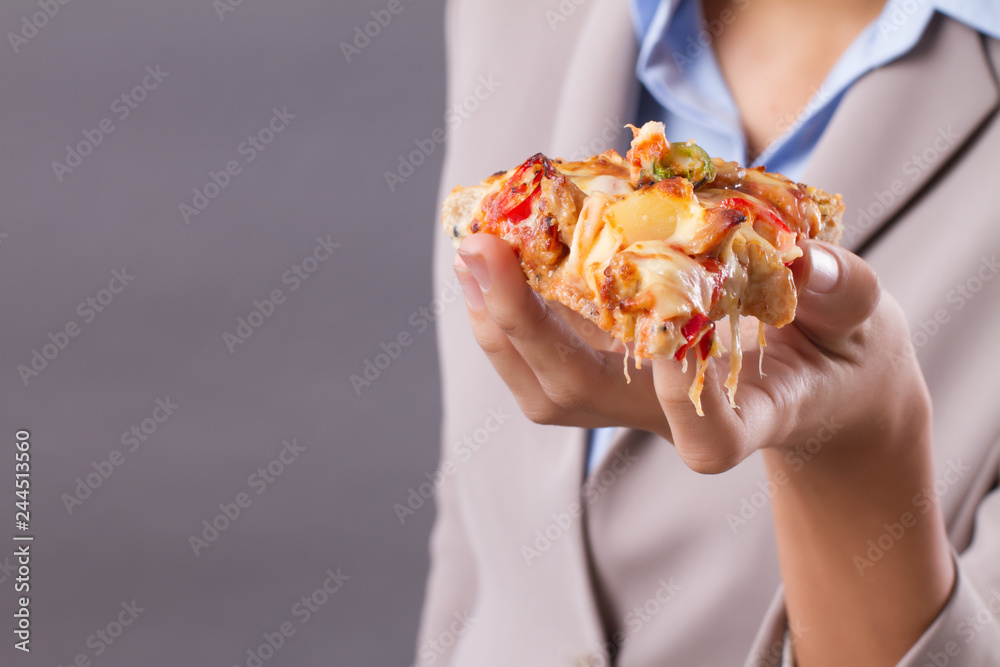 Hand of Asian woman holding and eating pizza; Portrait of south east Asian woman hand holding delicious italian pizza; enjoy eating pizza concept; Asian young adult, tan skin woman model Hand of Asian woman holding and eating pizza; Portrait of south east Asian woman hand holding delicious italian pizza; enjoy eating pizza concept; Asian young adult, tan skin woman model