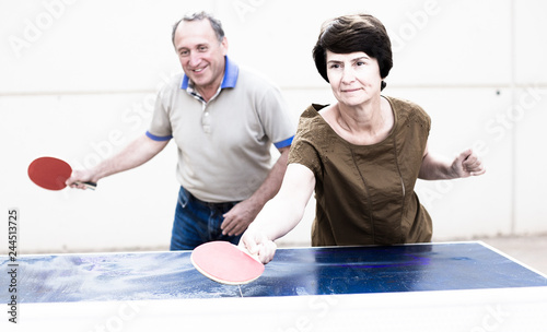 mature man and woman playing table tennis