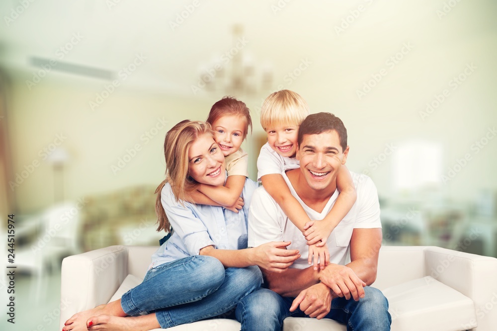 Beautiful smiling family sitting at sofa at home Beautiful smiling family sitting at sofa at home