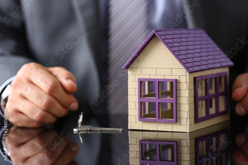 Man in suit and tie hold in hand silver key giving