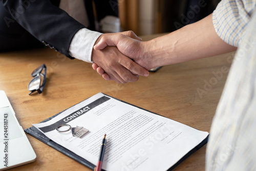Banker business man shaking hands with client and sign contrac document for comfirm corporation or finished loan agreement for house or building property.Document in photo is fake only for stock photo