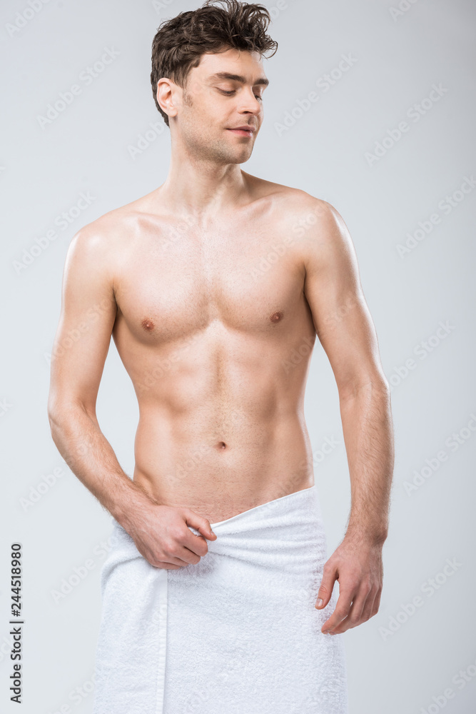 sexy shirtless smiling man posing in towel isolated on grey sexy shirtless smiling man posing in towel isolated on grey