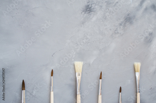 Drawing tools, set of clean paint brushes on gray background.