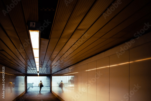 Passengers in a hurry at the end of a tunnel at the entrance to the metro station. photo
