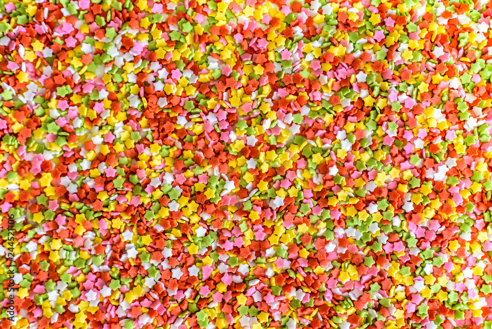 Close-up of colorful little stars made of sugar to decorate desserts, culinary background.