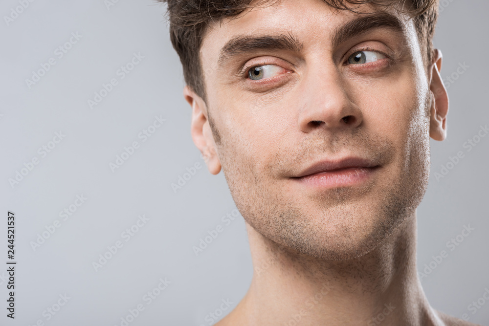 portrait of handsome young man looking away isolated on grey portrait of handsome young man looking away isolated on grey